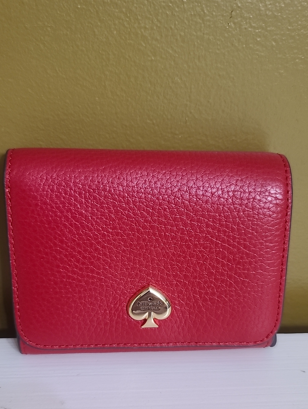 kate spade red pebbled leather trifold wallet with gold spade logo